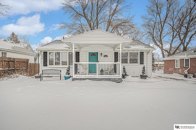 bungalow with covered porch and fence