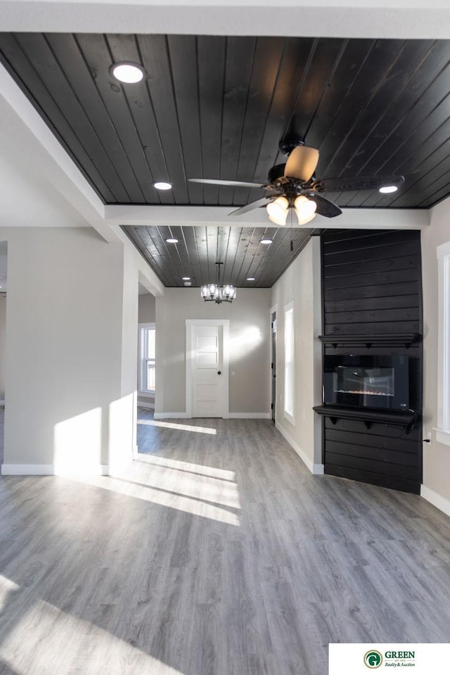 unfurnished living room featuring hardwood / wood-style flooring, ceiling fan with notable chandelier, and wooden ceiling