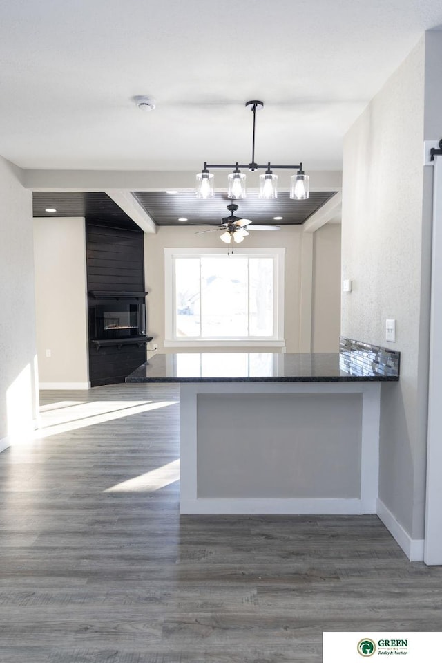 kitchen featuring dark hardwood / wood-style flooring, hanging light fixtures, and kitchen peninsula