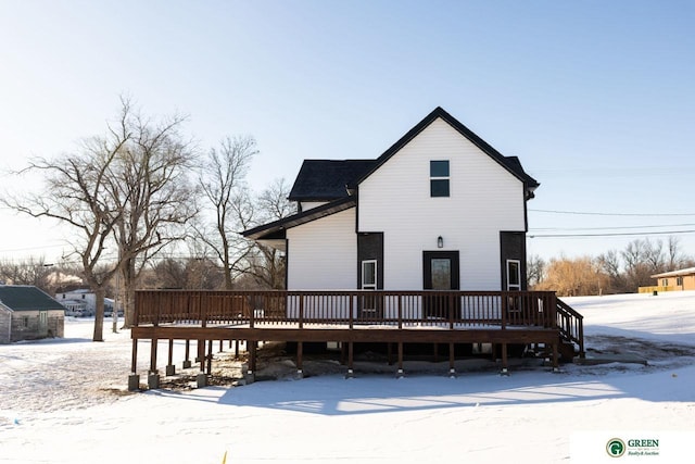 snow covered house featuring a wooden deck