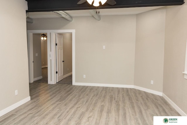 spare room featuring hardwood / wood-style floors, beam ceiling, and ceiling fan