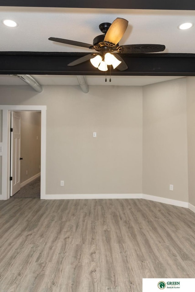 spare room with beam ceiling and light hardwood / wood-style flooring