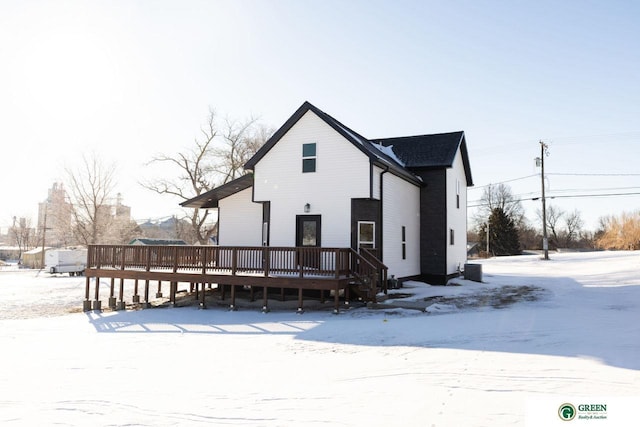 snow covered rear of property featuring a deck