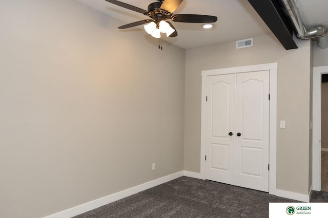 unfurnished bedroom featuring a closet, ceiling fan, and dark colored carpet