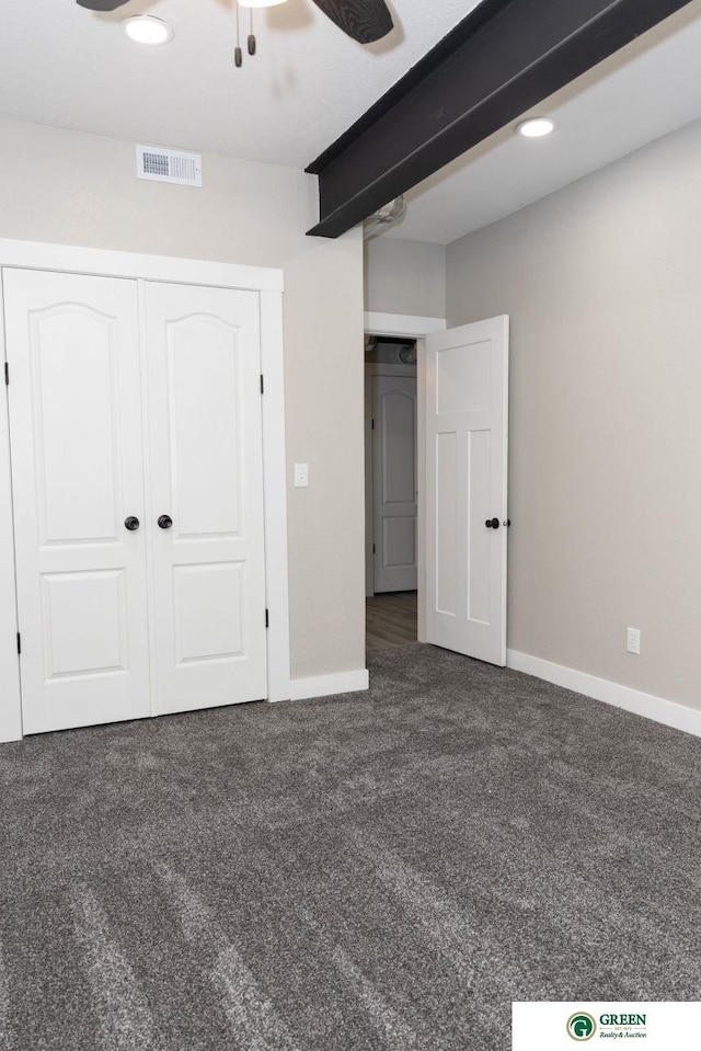 unfurnished bedroom featuring a closet and dark colored carpet