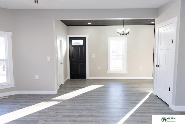 entrance foyer featuring an inviting chandelier and dark hardwood / wood-style flooring