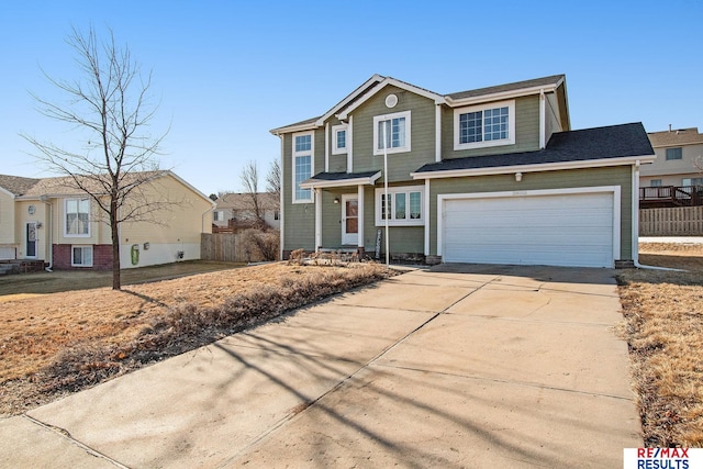 traditional-style home with driveway, a garage, and fence