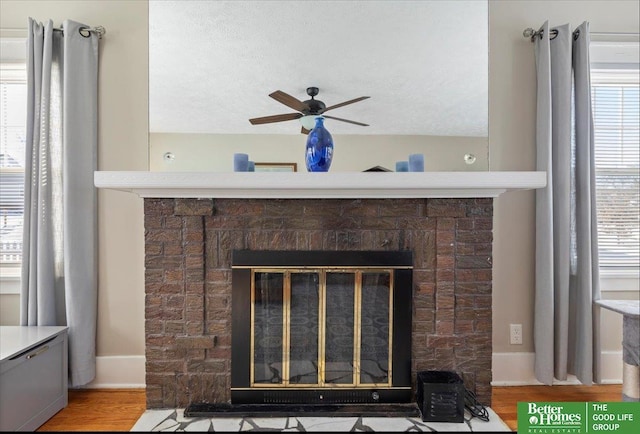 details featuring a brick fireplace, hardwood / wood-style floors, and ceiling fan