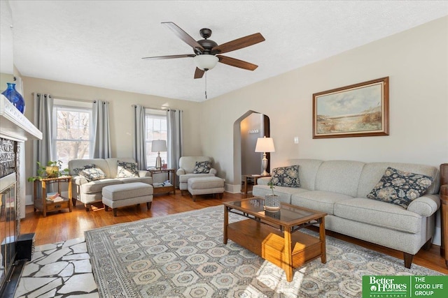 living room featuring ceiling fan, a textured ceiling, and light wood-type flooring