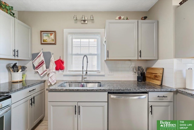 kitchen with sink, dishwasher, dark stone countertops, tasteful backsplash, and white cabinets