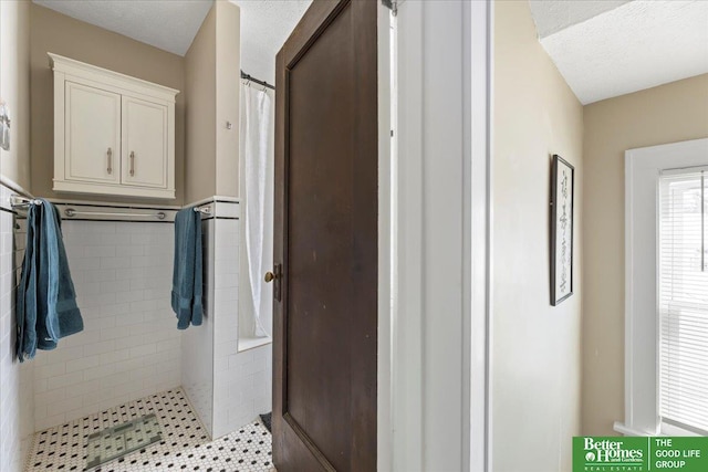 bathroom with walk in shower and a textured ceiling