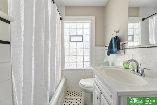 bathroom with vanity, tile walls, and toilet