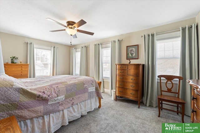 carpeted bedroom with multiple windows and ceiling fan