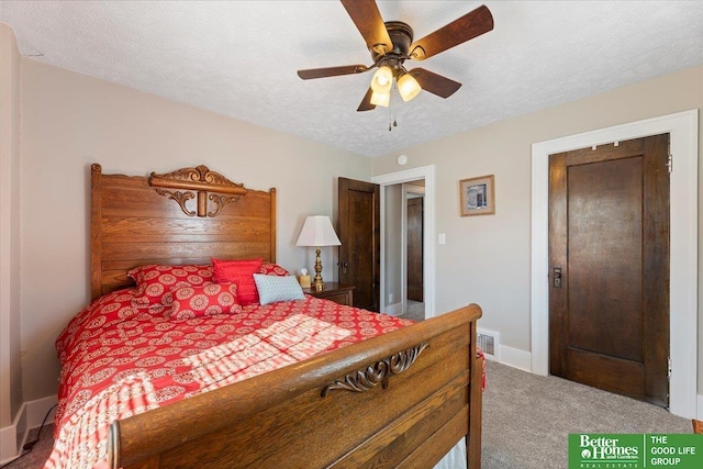 carpeted bedroom featuring ceiling fan and a textured ceiling