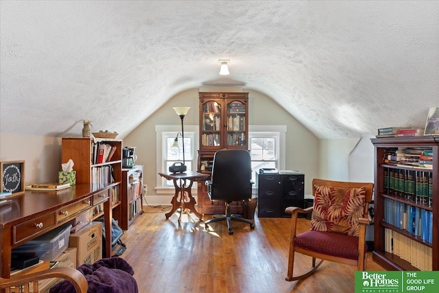 office area featuring hardwood / wood-style flooring, lofted ceiling, and a textured ceiling