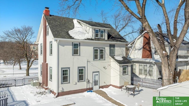 view of snow covered back of property