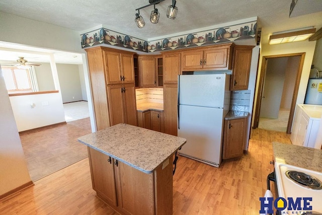 kitchen with water heater, a center island, white appliances, and light hardwood / wood-style flooring