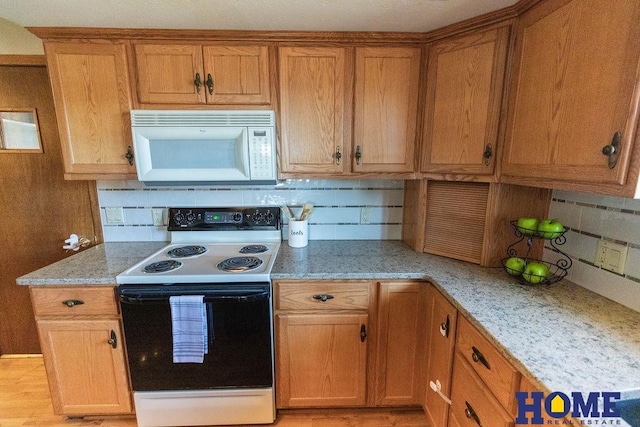 kitchen featuring light stone counters, electric range, decorative backsplash, and light wood-type flooring