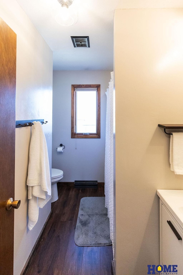 bathroom with hardwood / wood-style flooring, vanity, and toilet