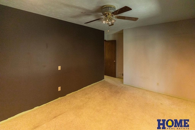 empty room featuring ceiling fan and carpet