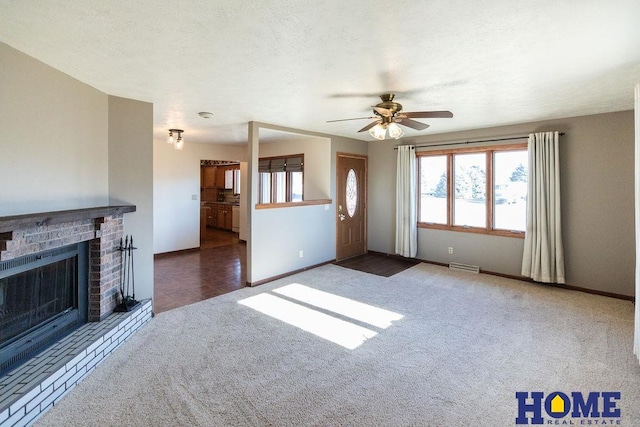 unfurnished living room with ceiling fan, a fireplace, carpet, and a textured ceiling