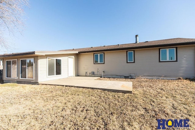 back of property with a patio area and a lawn