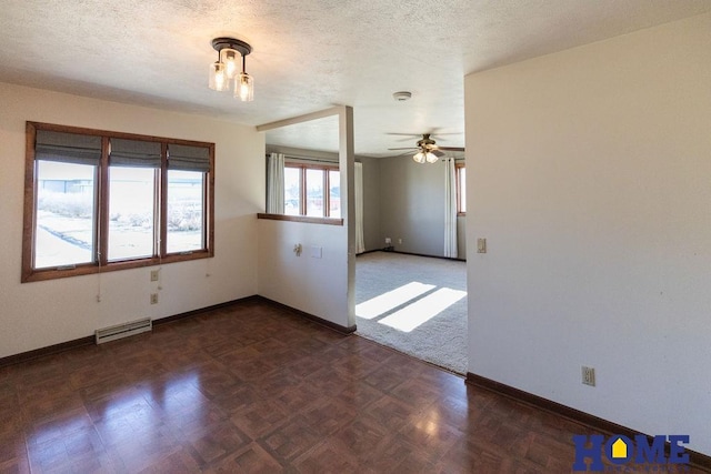 spare room featuring dark parquet flooring, ceiling fan, and a textured ceiling