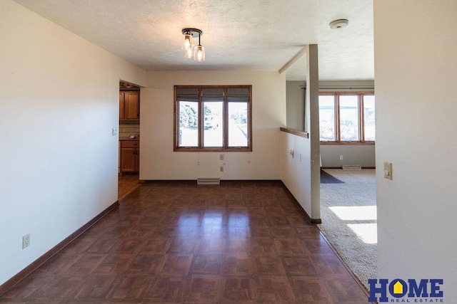 unfurnished room featuring dark parquet flooring and a textured ceiling