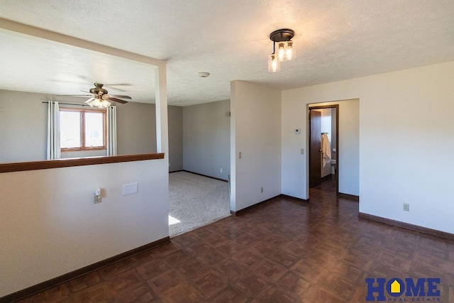 spare room featuring ceiling fan, dark parquet flooring, and a textured ceiling