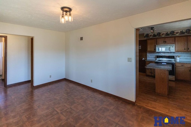 kitchen with range with electric stovetop, dark parquet floors, a textured ceiling, decorative backsplash, and kitchen peninsula