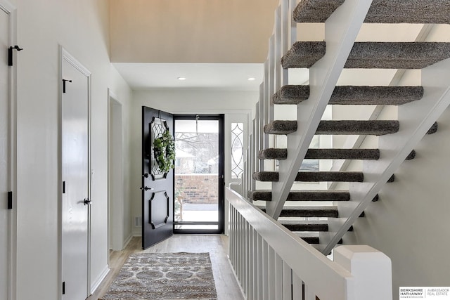 foyer featuring recessed lighting, stairway, a healthy amount of sunlight, and light wood-type flooring