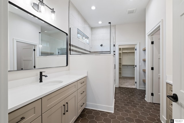 bathroom with vanity and a tile shower