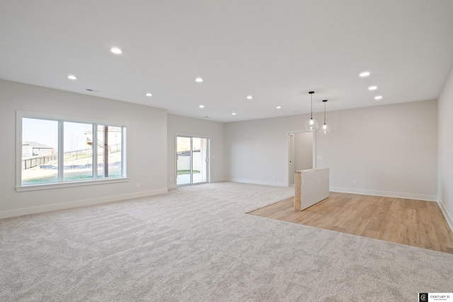 unfurnished living room featuring light colored carpet