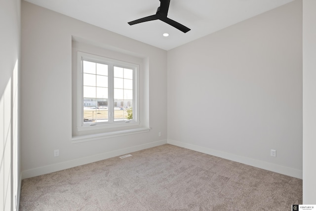 spare room with light colored carpet and ceiling fan