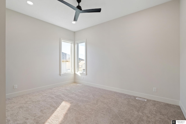 spare room with light colored carpet and ceiling fan