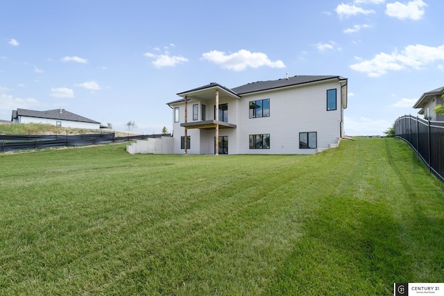 rear view of property with a balcony and a yard