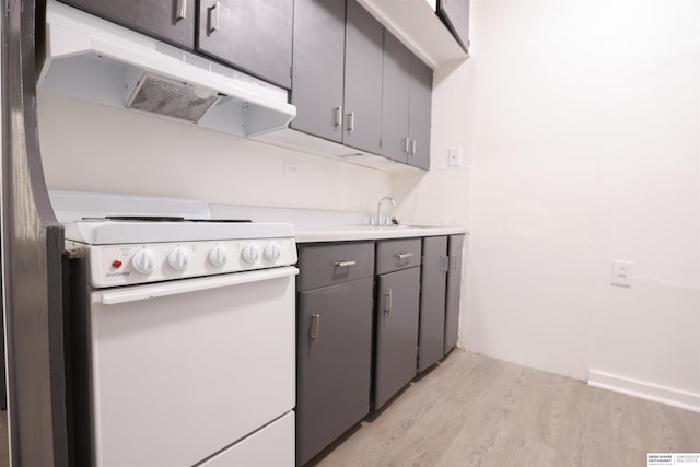 kitchen featuring sink, light hardwood / wood-style floors, and white range with electric stovetop