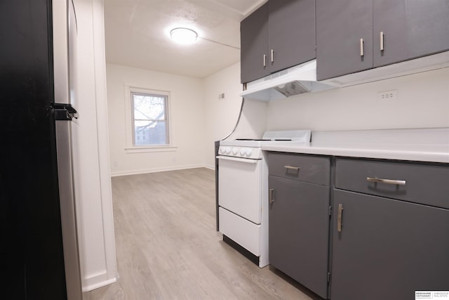 kitchen featuring light hardwood / wood-style flooring, stainless steel refrigerator, and white range with electric cooktop