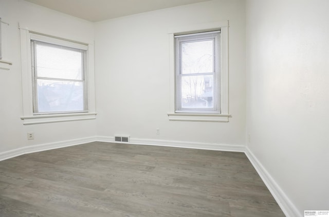 empty room featuring ornamental molding and dark hardwood / wood-style flooring