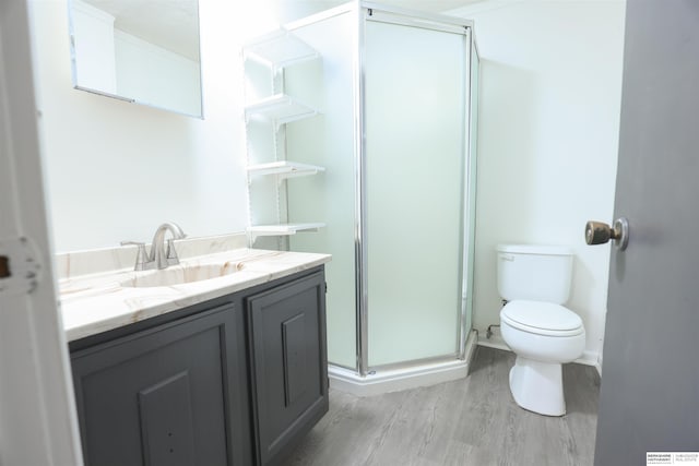 bathroom featuring vanity, wood-type flooring, an enclosed shower, and toilet