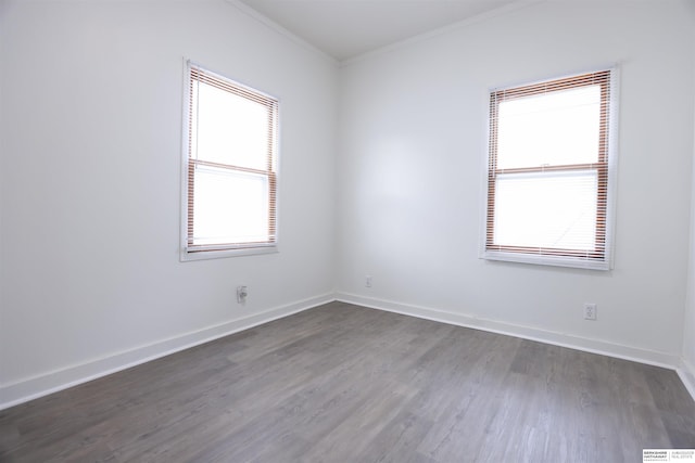 empty room with dark wood-type flooring and ornamental molding