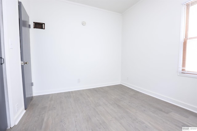 spare room with crown molding and light hardwood / wood-style flooring