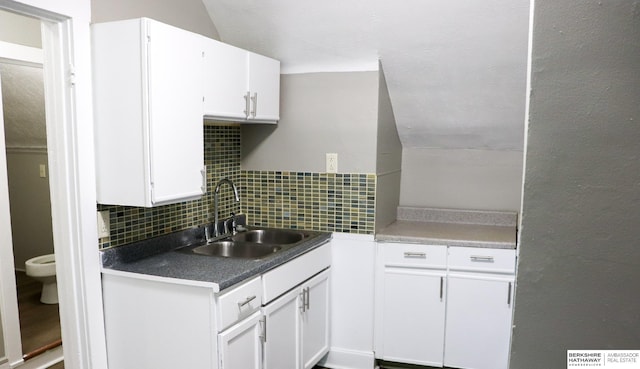 kitchen featuring sink, decorative backsplash, and white cabinets