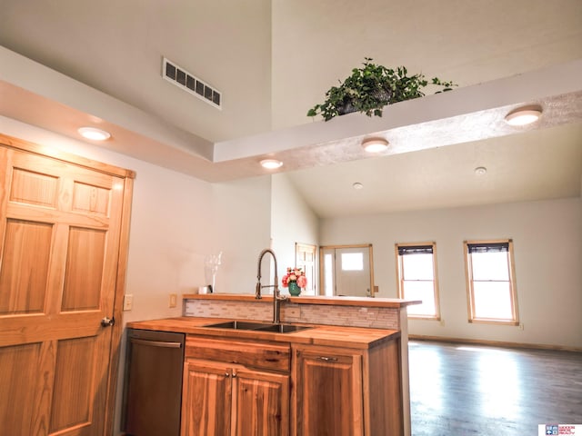 kitchen with wood-type flooring, sink, stainless steel dishwasher, and butcher block countertops