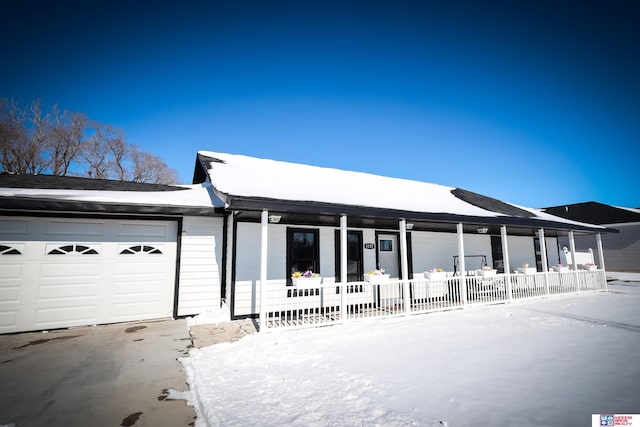 ranch-style house featuring a garage and covered porch