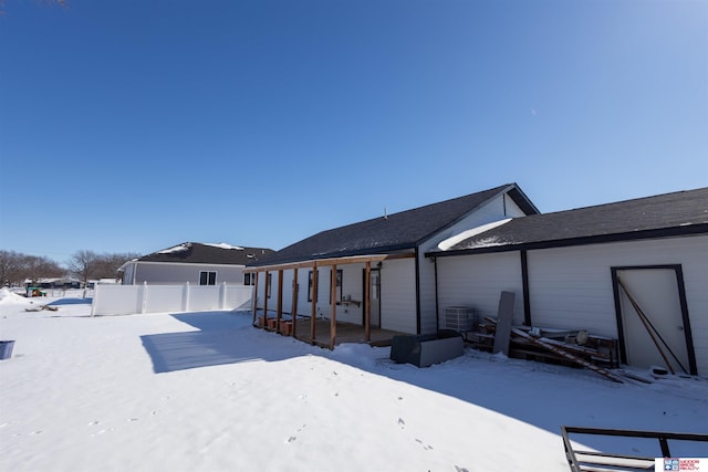 snow covered rear of property with central air condition unit