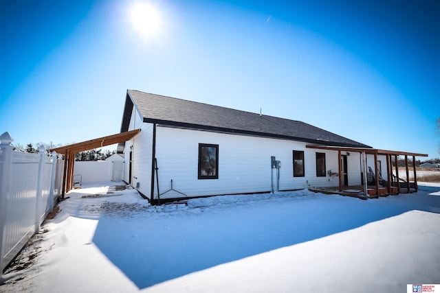 view of snow covered back of property