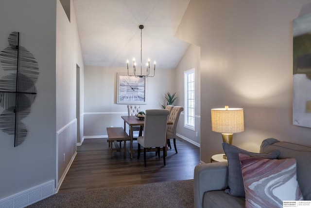 dining room featuring dark hardwood / wood-style floors, a chandelier, and vaulted ceiling