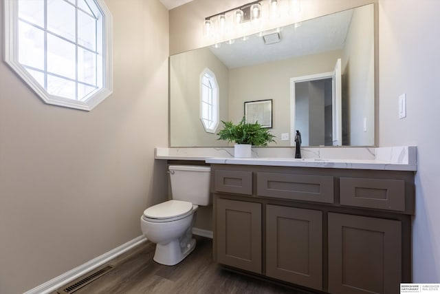 bathroom with hardwood / wood-style flooring, vanity, and toilet