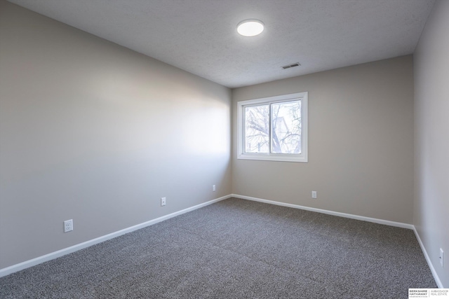 carpeted empty room with a textured ceiling